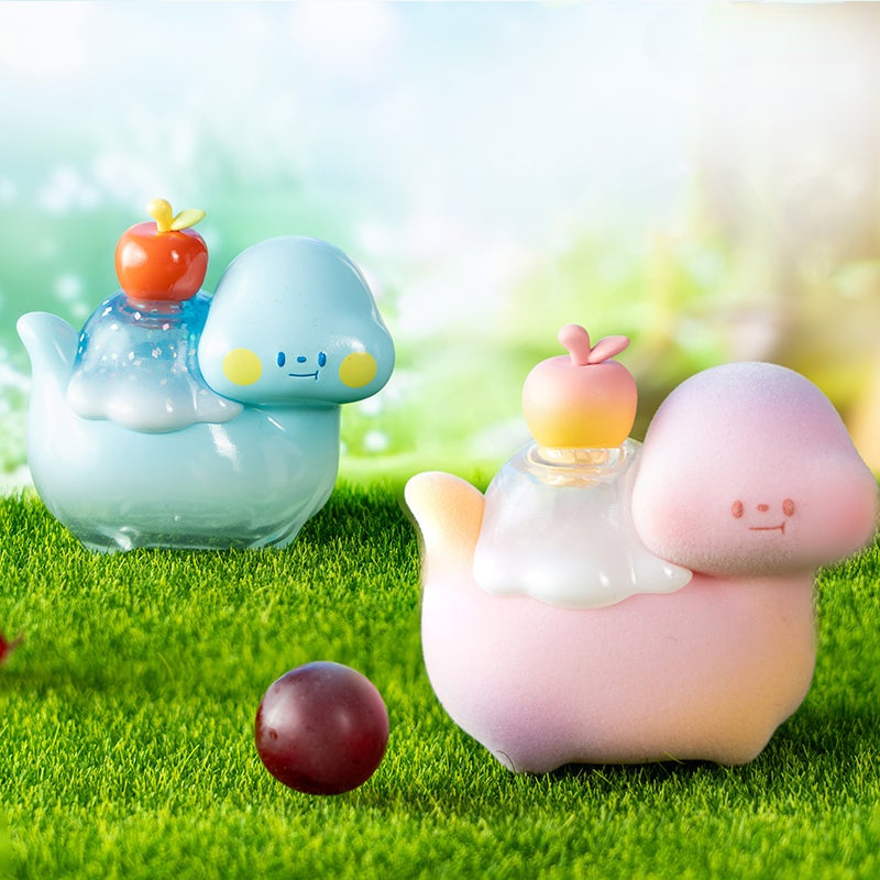Two cartoonish teapots with apple on top on a grassy background