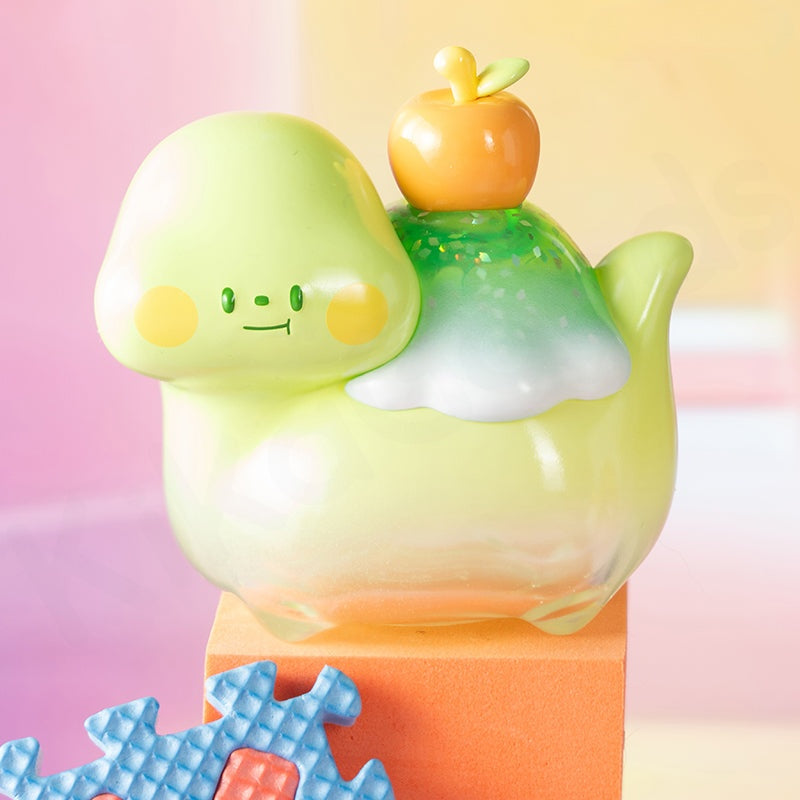 Colorful toy with a green character and orange top on a gradient background