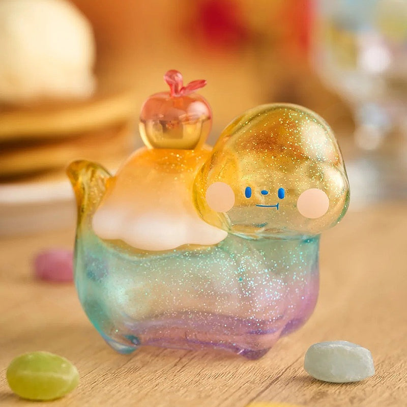 Colorful glass figurine with a smiling face on a wooden surface