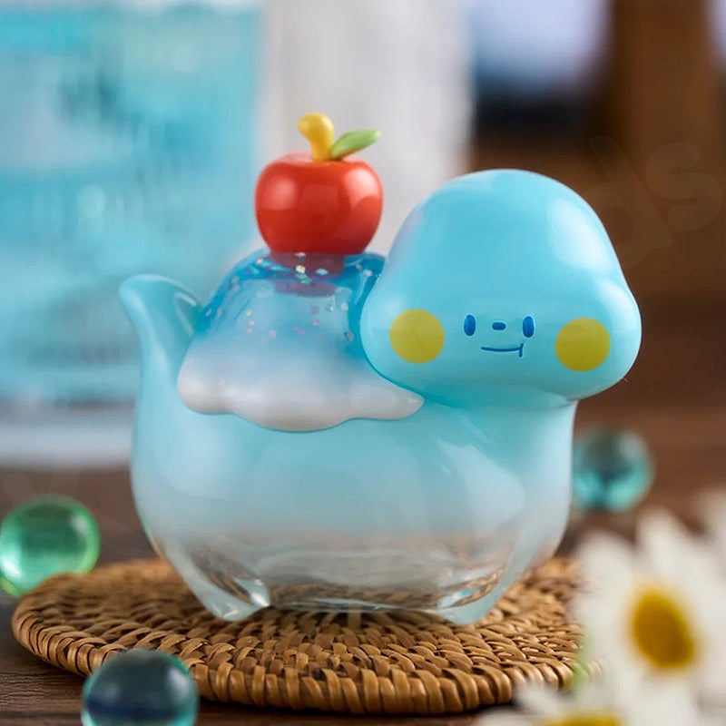 Blue cloud-shaped teapot with a cherry on top on a woven coaster