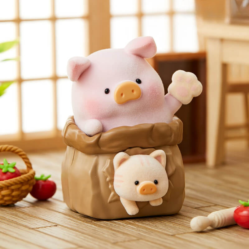 Two plush pig toys in a wooden barrel on a wooden floor with a blurred background