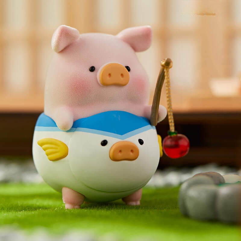 Cute pig figurine with a fish design on a grassy surface