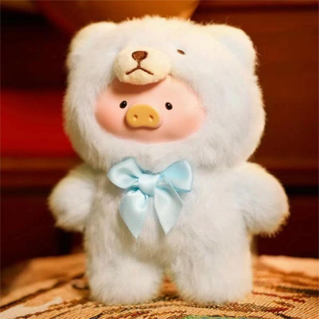 Stuffed toy resembling a pig in a white outfit with a blue bow on a wooden surface.