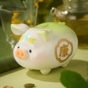 White pig-shaped ceramic money box with decorative elements on a green surface