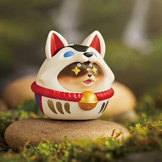 Decorative cat figurine with a traditional outfit on a stone in a natural setting