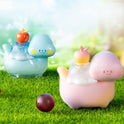 Two cartoonish teapots with apple on top on a grassy background