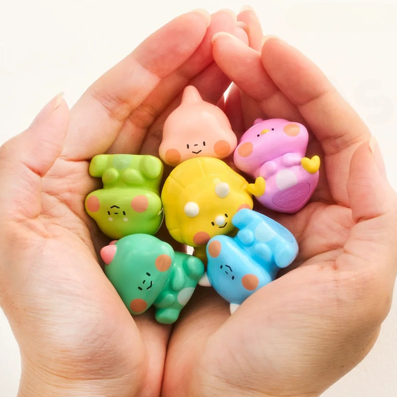Colorful cartoon-like erasers held in a hand against a white background