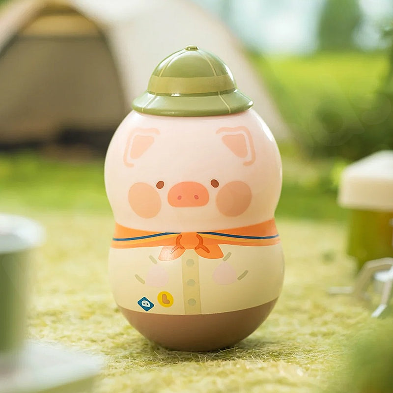 Toy piggy bank with a green lid on grass
