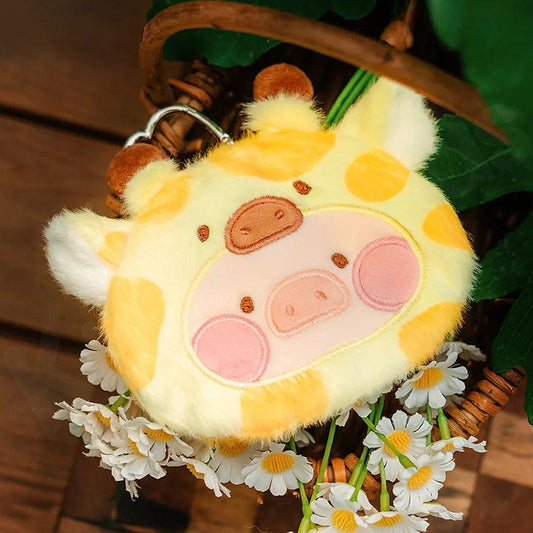 Plush keychain shaped like a cow with yellow and pink colors, surrounded by flowers and leaves.
