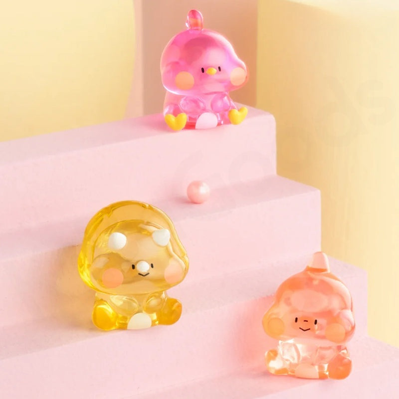 Three colorful character figurines on a pink platform with a yellow background