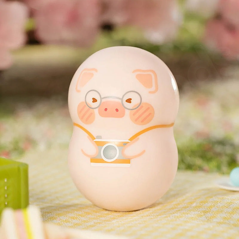 Cute pig-shaped product with glasses and a camera on a blurred outdoor background