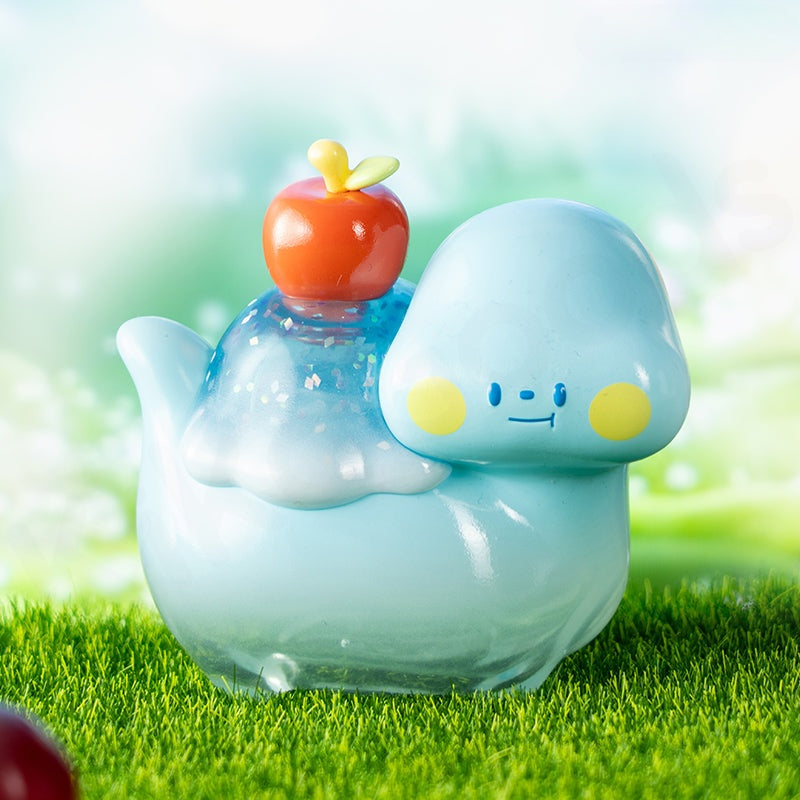 Toy figure of a blue creature with a smiling face on a grassy background