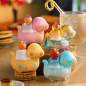 Colorful glass figurines on a wooden surface with a blurred background