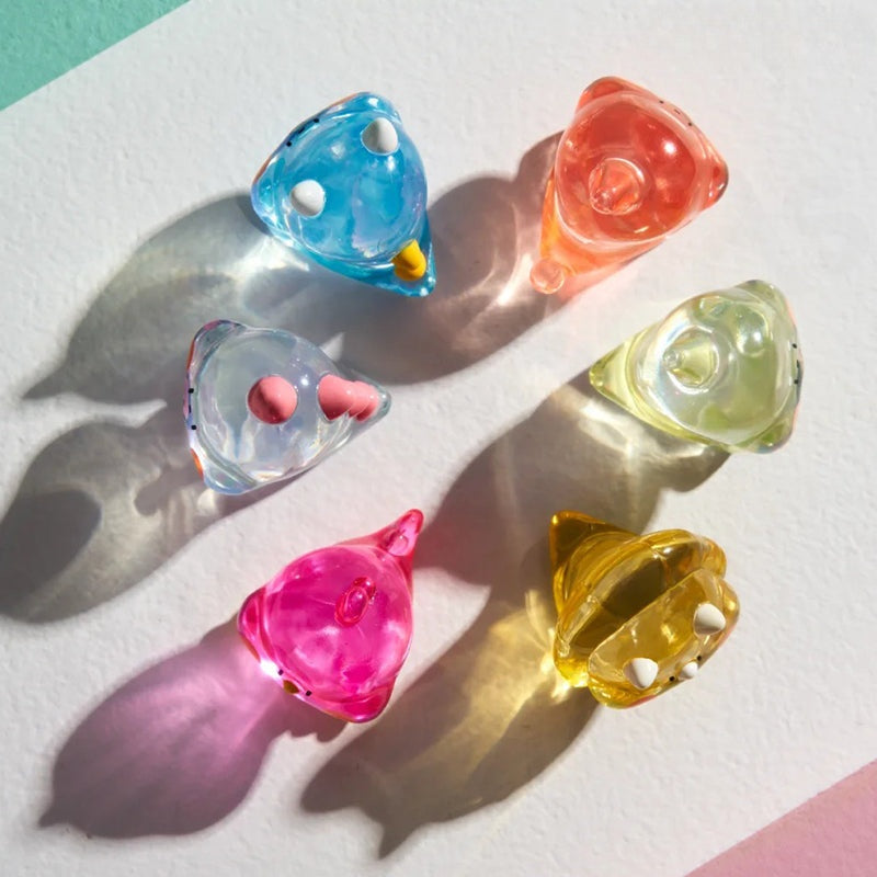 Colorful catnip toys on a light surface with shadows