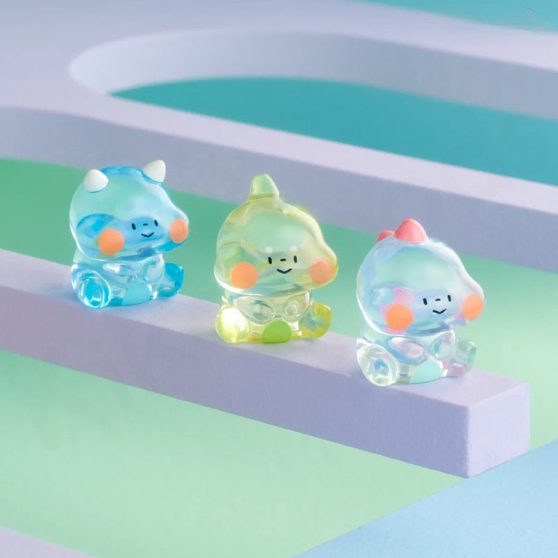 Three colorful, transparent figurines on a pastel background