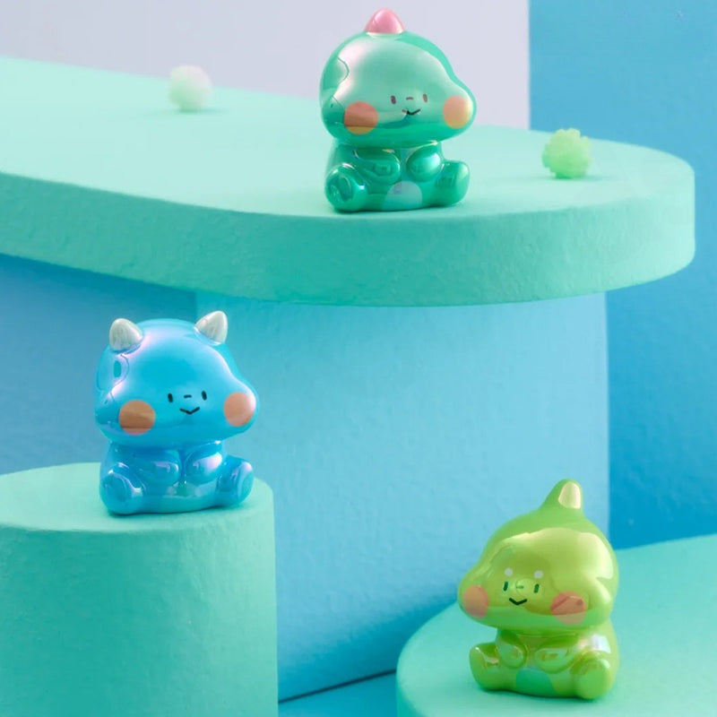 Three colorful animal figurines on a geometric blue and green background
