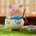 Cute pig figurine with a fish design on a grassy surface