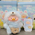 Plush toy in a blue costume with a bear design, standing in front of 'TOYZERO+' branded boxes.