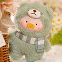 Two teddy bears in blue and green with scarves on a soft surface.