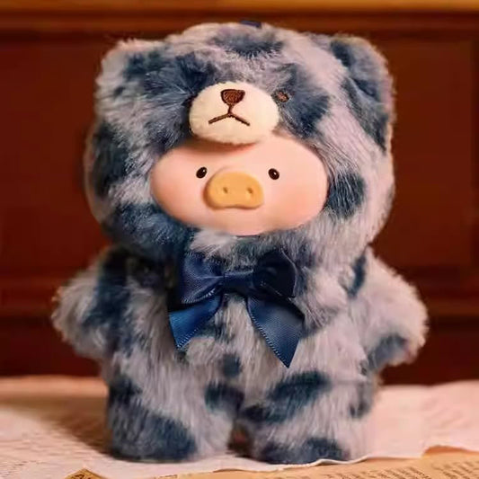 Plush toy with a blue and gray patterned hood and bow tie on a wooden surface.