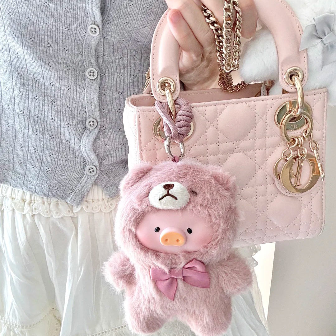 Pink teddy bear keychain attached to a Dior handbag